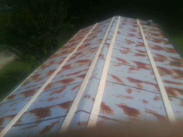 Rusted metal roof panels with new wood purlins before replacement — Storm Damage Roof Repair in Griffin by Roofing Brothers
