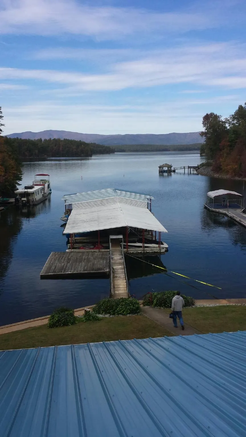 View across a lake from a newly installed blue metal roof in Griffin